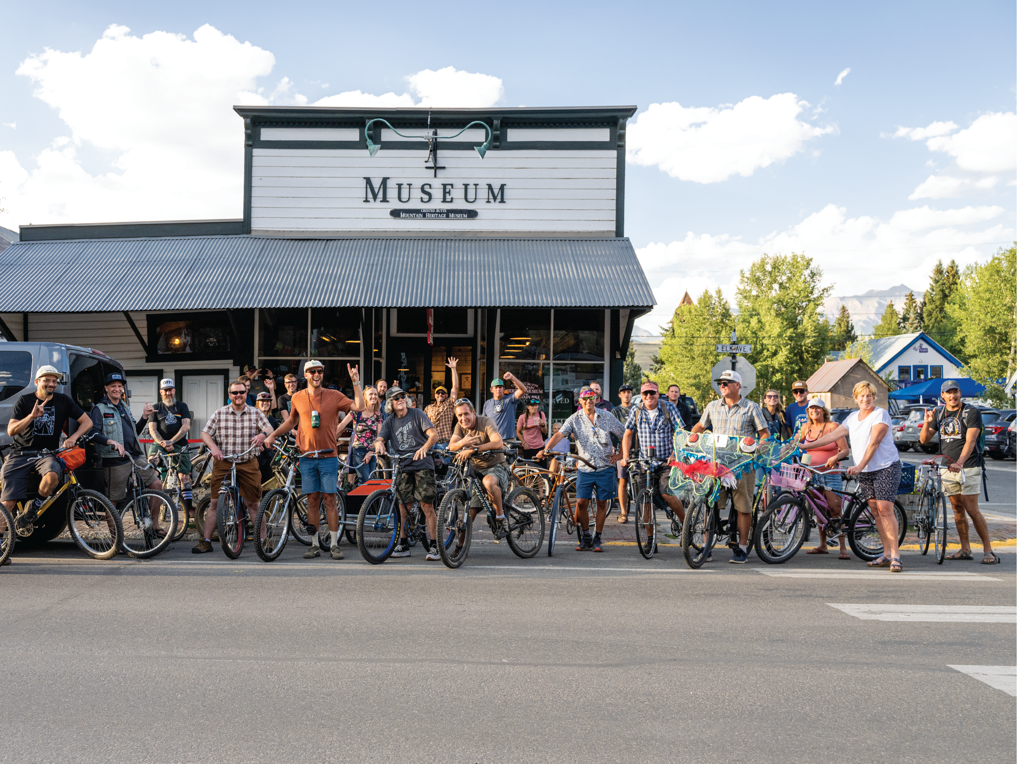 people on bikes posing in front of the museum 